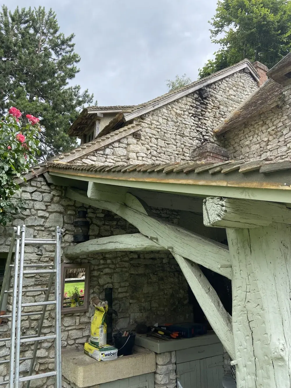 Charpente d'auvent en bois sur une maison en pierre
